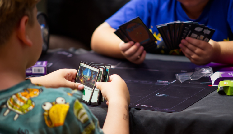 Two players with cards in hand ready to start a Magic the Gathering adventure